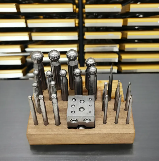 Jewelry crafting tools including gold, iron, and silver manual punch heads, anvil, steel mold, and large four-sided and six-sided pits are available, accompanied by a one-year warranty.